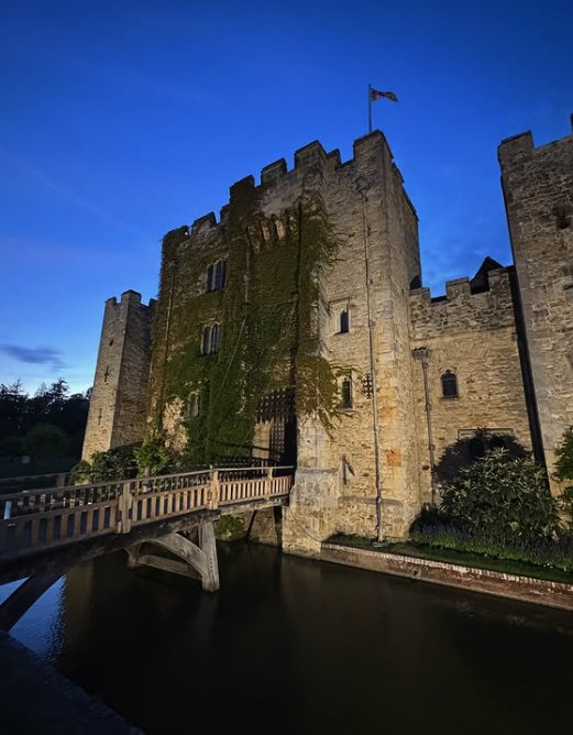The bridge and gatehouse at Hever Castle lit up against a night sky
