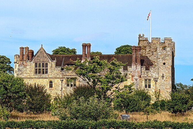 Hever Castle's chimneys and battlements rising above the garden hedges