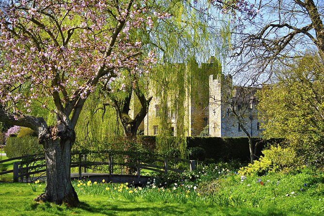 Blossom on the trees beside the water, with Hever Castle behind