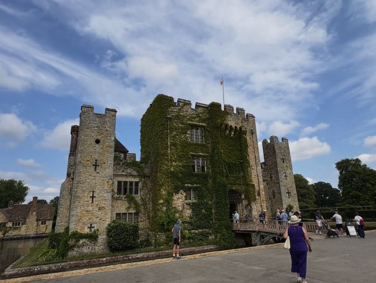 The walk across the bridge towards Hever Castle's ivy-covered gatehouse